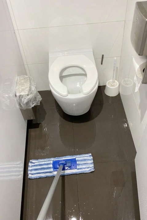 Bathroom floor being cleaned with a mop