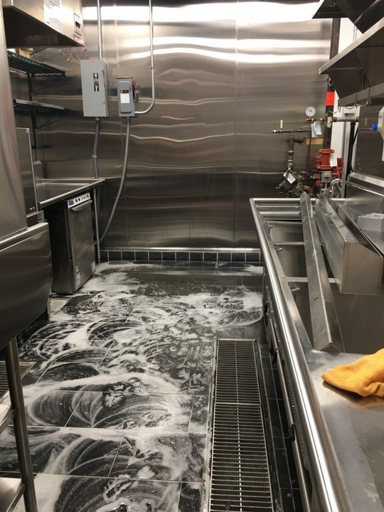 Commercial kitchen floor being deep cleaned