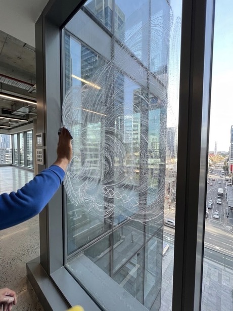 Cleaner washing a large office window